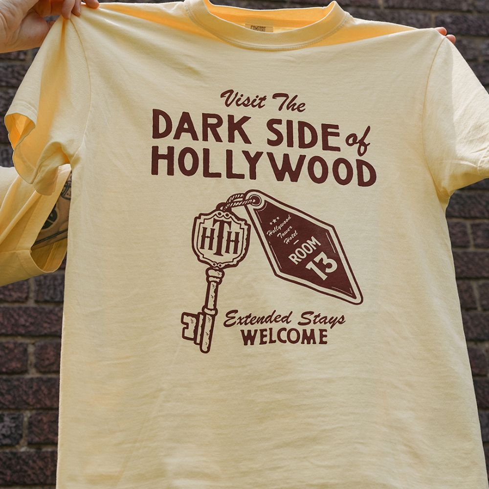 Front view of Disney-inspired Dark Side of Hollywood t-shirt featuring the phrase ‘Visit The Dark Side of Hollywood,’ an image of a hotel key labeled Room 13, and the text ‘Extended Stays Welcome.'