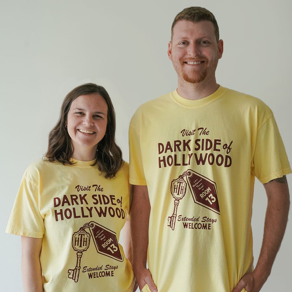 Front view of Disney-inspired Dark Side of Hollywood t-shirt featuring the phrase ‘Visit The Dark Side of Hollywood,’ an image of a hotel key labeled Room 13, and the text ‘Extended Stays Welcome.'