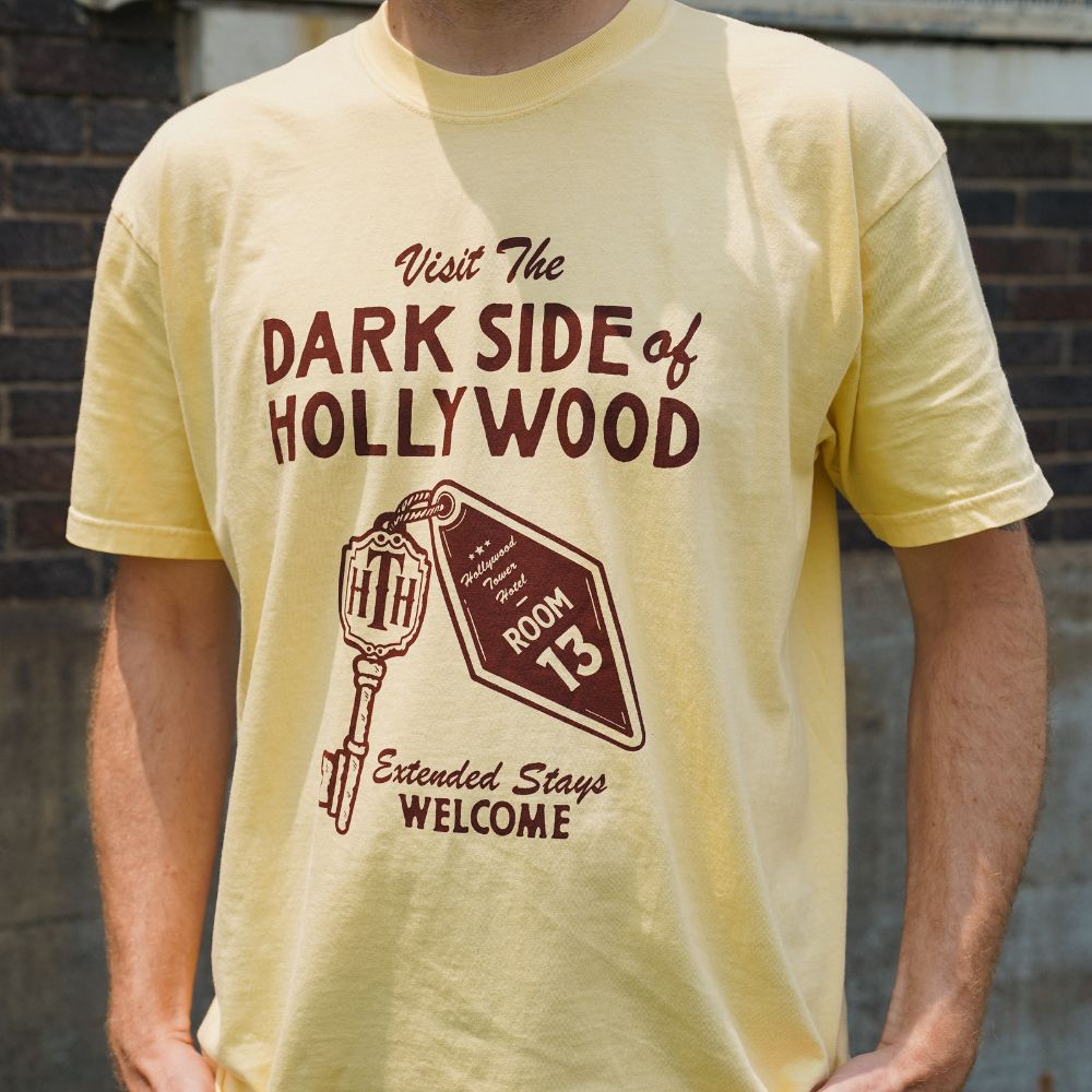 Front view of Disney-inspired Dark Side of Hollywood t-shirt featuring the phrase ‘Visit The Dark Side of Hollywood,’ an image of a hotel key labeled Room 13, and the text ‘Extended Stays Welcome.'
