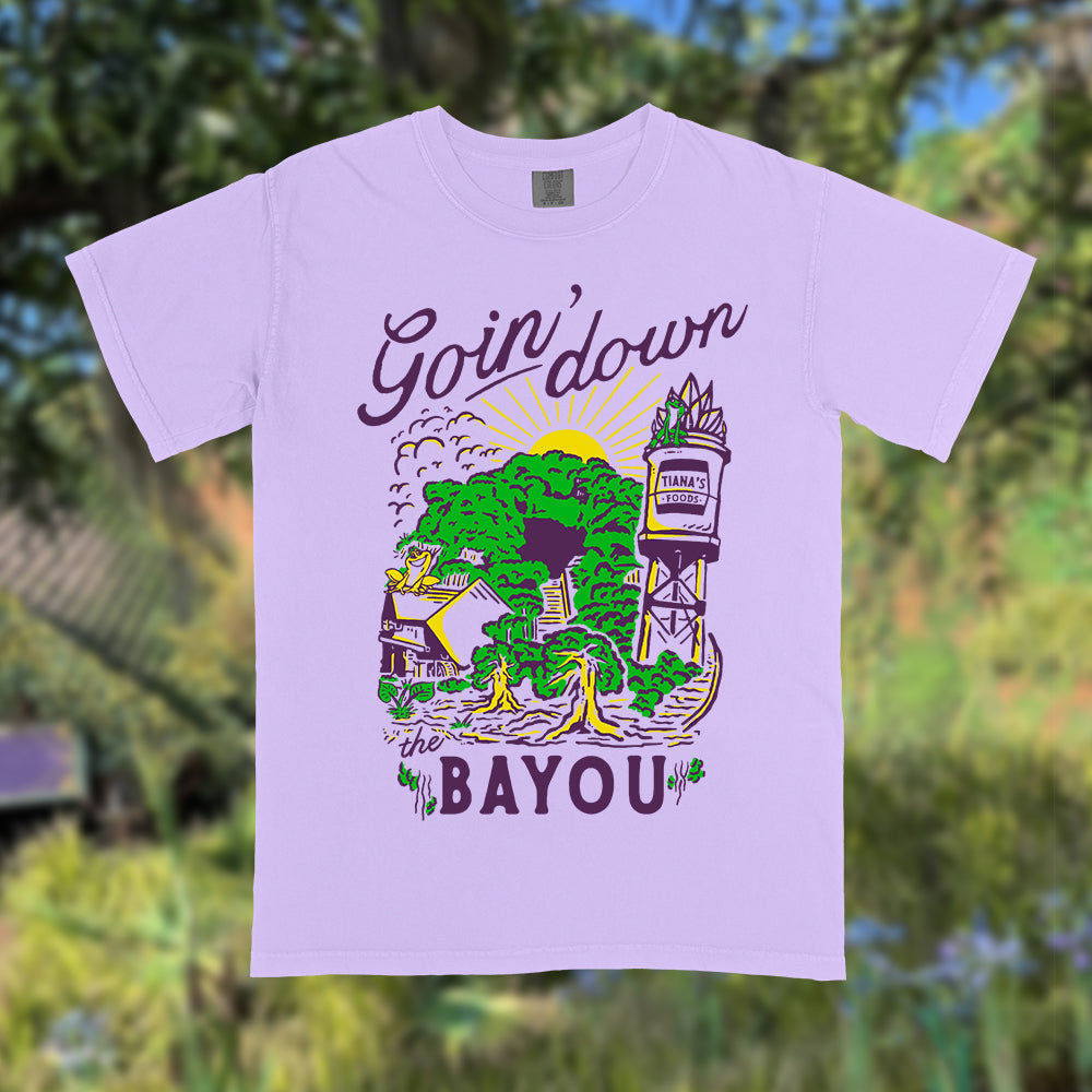 Front view of Disney-inspired Goin’ Down the Bayou t-shirt featuring text ‘Goin’ Down the Bayou’ above artwork of Tiana’s Bayou Adventure ride exterior with the big drop, Tiana’s Foods water tower, and cypress trees.