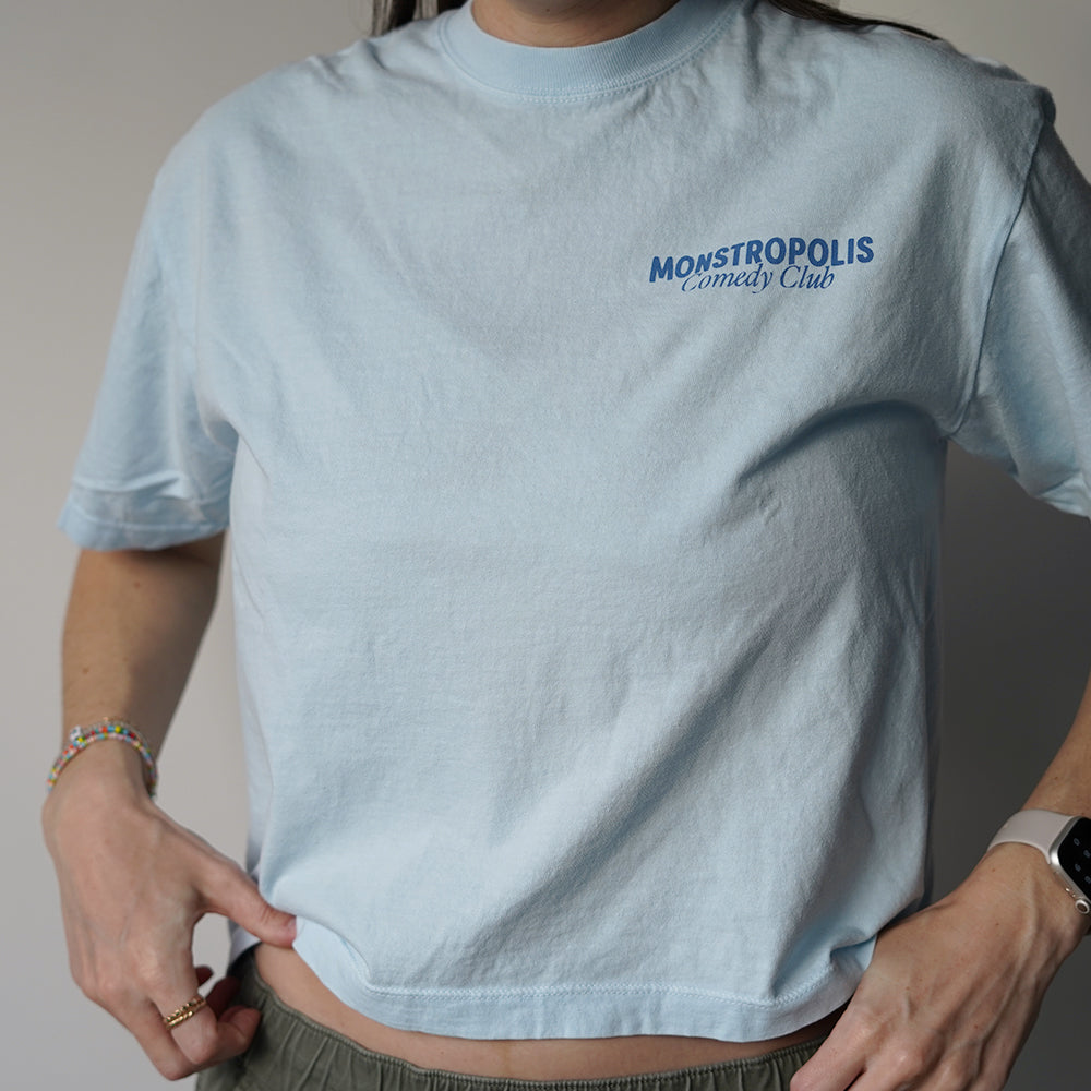 Front view of Disney-inspired Monstropolis Comedy Club crop top with small left chest logo text reading Monstropolis Comedy Club.