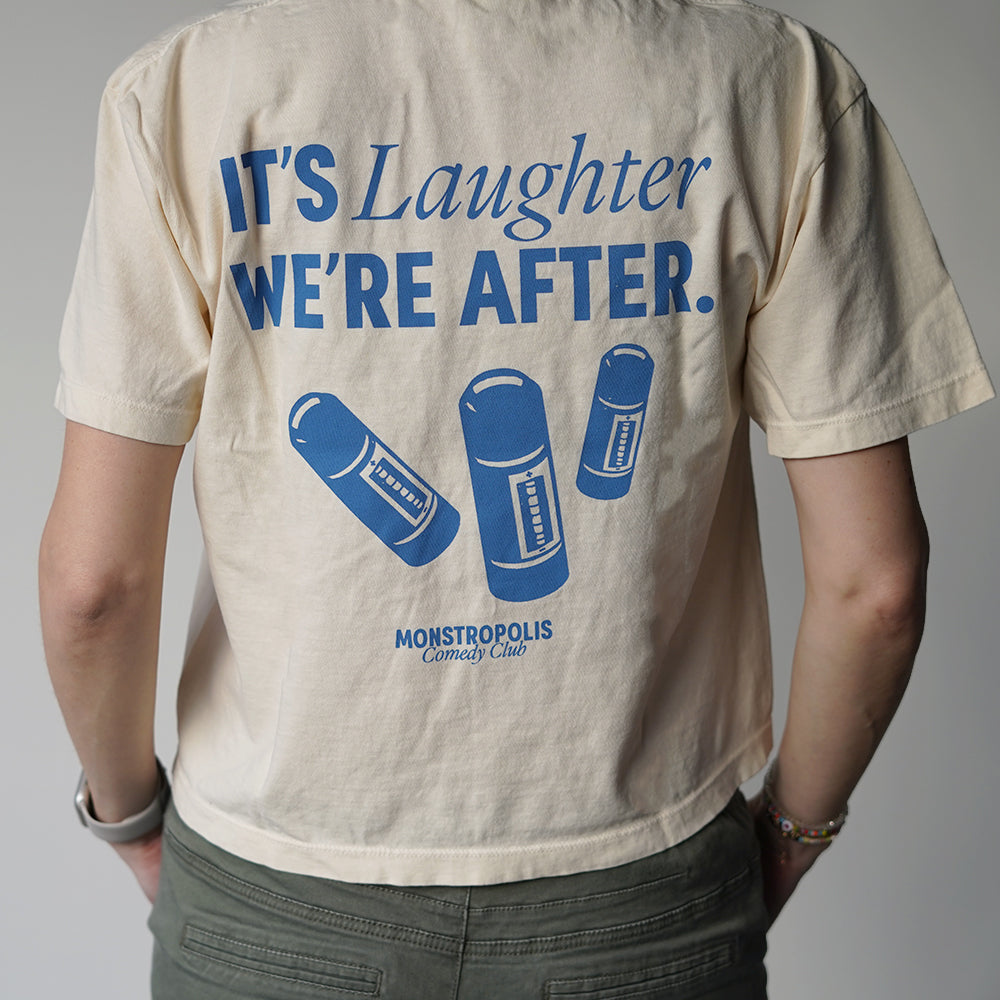Back view of Disney-inspired Monstropolis Comedy Club crop top with the phrase ‘It’s Laughter We’re After’ above three laugh canisters and Monstropolis Comedy Club text underneath.