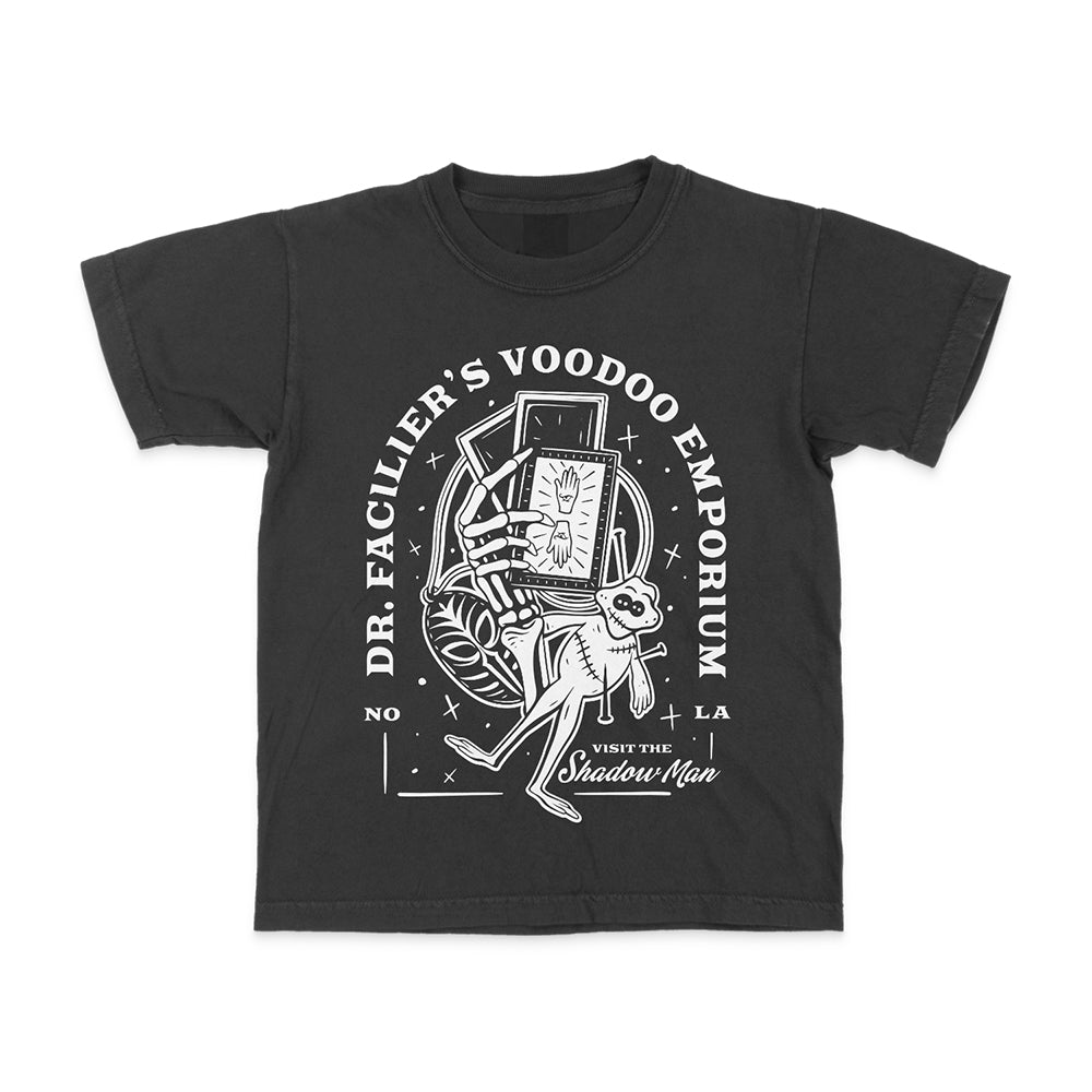 Front view of Disney-inspired Dr. Facilier’s Voodoo Emporium t-shirt with text ‘Dr. Facilier’s Voodoo Emporium,’ ‘NOLA,’ and ‘Visit the Shadow Man,’ featuring a voodoo frog and a skeleton hand holding playing cards.